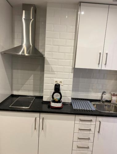 a kitchen with white cabinets and a sink and a stove at WILLMARk 1 in Salamanca