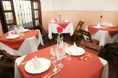 uma sala de jantar com mesas e cadeiras vermelhas e brancas em Hotel Huasi Continental em Quito