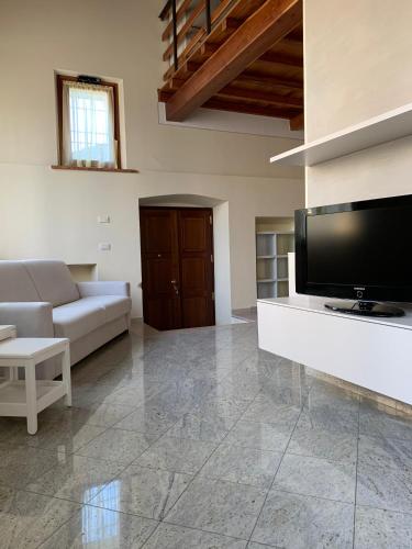 a living room with a television and a couch at Il Vicoletto holiday house in Volta Mantovana