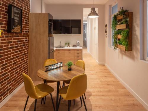 uma cozinha com uma mesa e cadeiras com um sinal feliz em MIMA Suites Chueca em Madri