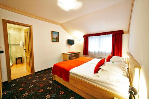 
a hotel room with a bed and a dresser at Alp Pension in Bled
