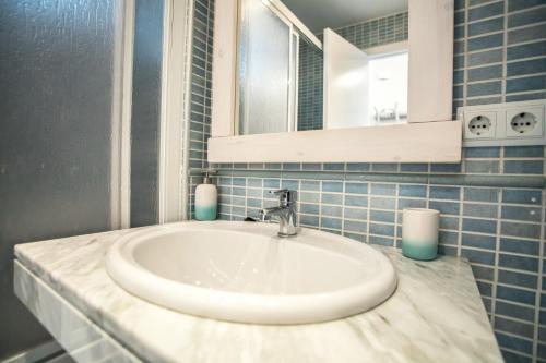 een badkamer met een witte wastafel en een spiegel bij Luna in Sierra Nevada