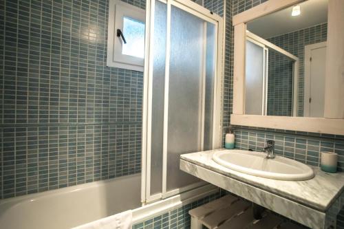 een blauw betegelde badkamer met een wastafel en een spiegel bij Luna in Sierra Nevada