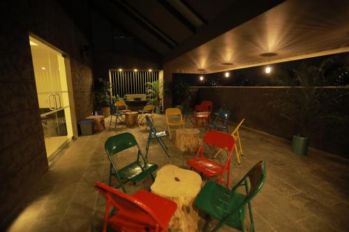 a patio with colorful chairs and a table and a table and chairs at Zoot Kochi Infopark in Cochin