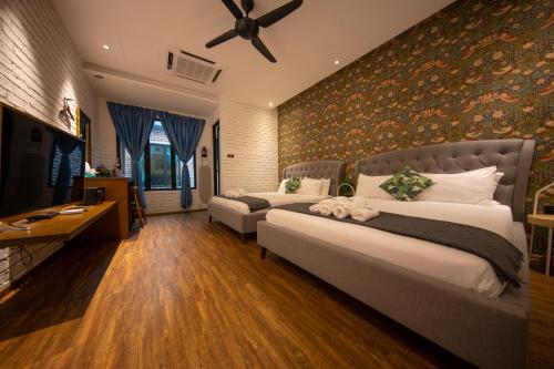 a bedroom with two beds and a flat screen tv at Carnarvon Suites in George Town