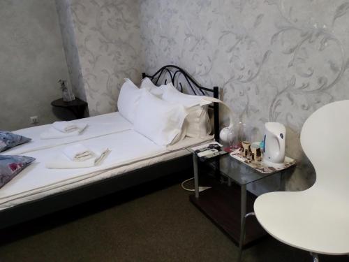 a bed with white pillows and a table with a lamp at Hotel Perfect in Varna City