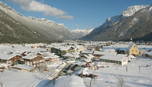 a town covered in snow with mountains in the background at Hotel Tiroler Adler - bed and breakfast in Waidring