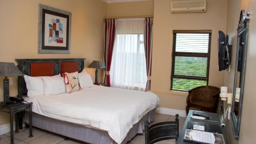 a bedroom with a bed and a window at Premier Hotel The Richards in Richards Bay