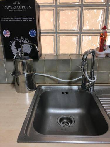 a kitchen sink with a faucet on top of it at Bianco E U Apartment in Nicosia