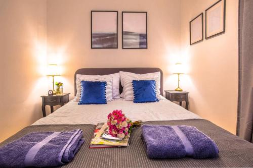 een slaapkamer met een bed met paarse kussens en een dienblad met bloemen bij Number 28 Boutique Apartment in Zagreb