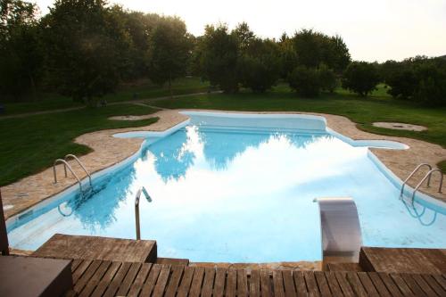una piscina de agua azul en un patio en Hotel Rural Peña Del Alba en Arroyomolinos de la Vera