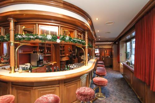 a bar in a restaurant with stools at Hotel Tiroler Adler - bed and breakfast in Waidring