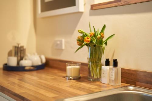 a vase of flowers sitting on a counter next to a sink at No 88 UPPER ST GILES - Elegant, Stylish Townhouse in Norwich