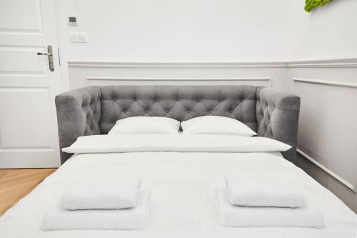 una camera da letto con un grande letto con cuscini bianchi di HOUSEHOST Apartment I: Studencka Street a Cracovia