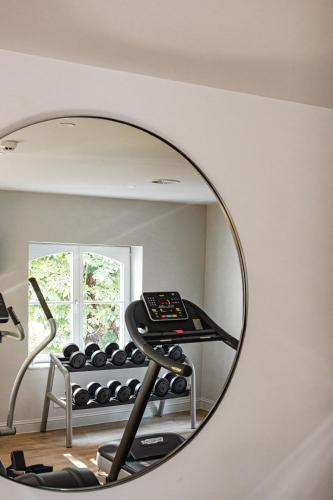 a mirror in a room with a gym at Pillows Grand Boutique Hotel Reylof Ghent in Ghent