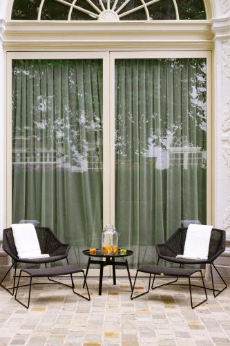 two chairs and a table in front of a window at Pillows Grand Boutique Hotel Reylof Ghent in Ghent