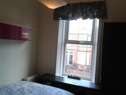 a bedroom with a window with a bed and a desk at Avenue Road in Gateshead
