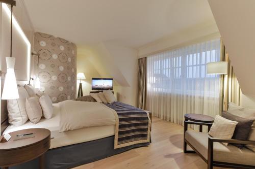 a hotel room with a large bed and a window at Severin's Resort & Spa in Keitum