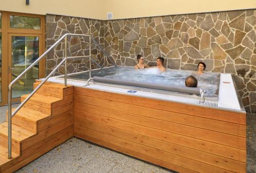 three people in a hot tub in a building at Hotel Resort Relax in Dolní Vltavice