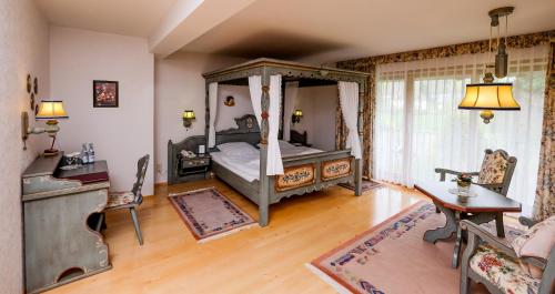 ein Schlafzimmer mit einem Himmelbett und einem Holzboden in der Unterkunft Harzer Hof in Herzberg am Harz