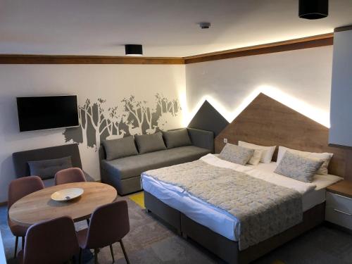 ein Schlafzimmer mit einem Bett, einer Couch und einem Tisch in der Unterkunft Apartment 101 - Aparthotel Vucko Jahorina private host in Jahorina