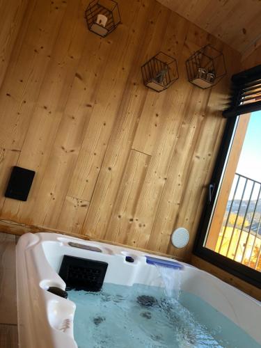 a bath tub in a room with a wooden ceiling at Clos Shambhala-Chalet d'hôtes in Saint-Jean-Saint-Nicolas