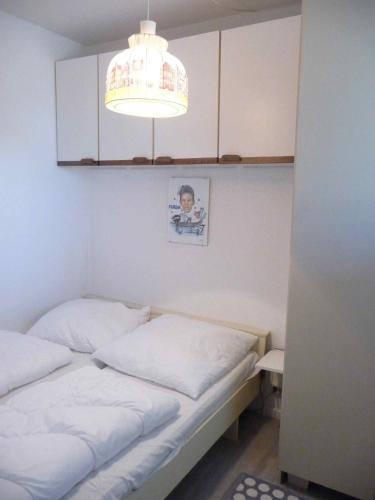 a small bedroom with two beds and a light at STHS79125-FeWo-Oostseebreker in Staberdorf