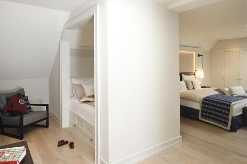 a bedroom with a mirror and a bed and a chair at Severin's Resort & Spa in Keitum