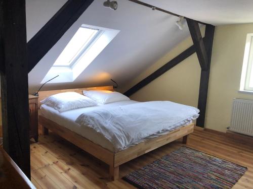 Schlafzimmer mit einem Bett und einem Dachfenster in der Unterkunft Gründerhaus in Dießen am Ammersee