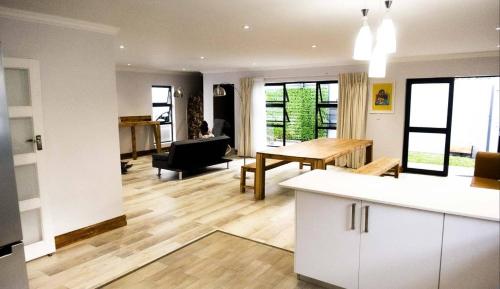 a kitchen and living room with white cabinets and a table at Explorer Backpackers in Johannesburg