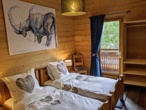 a bedroom with two beds and a picture of an elephant at Chalet Neve in Les Deux Alpes