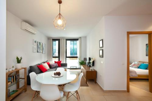 una sala de estar con una mesa y un sofá en Alohamundi San Julián, en Sevilla