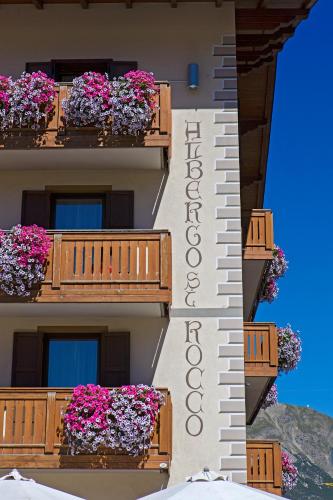a building with flower boxes on the balconies at Hotel San Rocco in Livigno