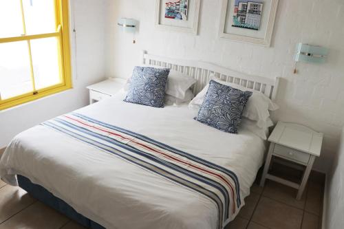 a bed with two pillows on it in a bedroom at Kaliva 364 at Club Mykonos in Langebaan in Langebaan