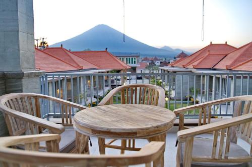 a wooden table and chairs on a balcony at Seamount Hotel Amed in Amed