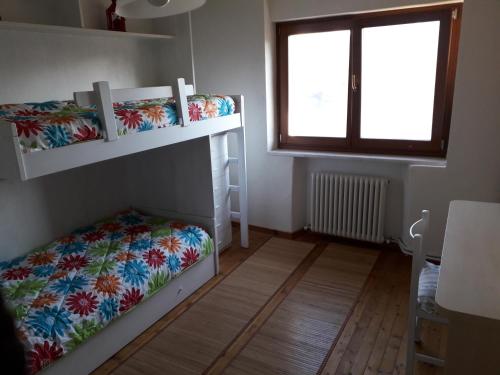 Pokój z 2 łóżkami piętrowymi i oknem w obiekcie Maso Pianezza House w mieście Calceranica al Lago