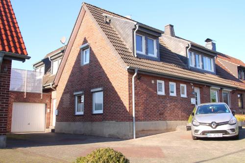 a car parked in front of a brick house at Ferienwohnung Auf der Blumenstrasse in Nettetal
