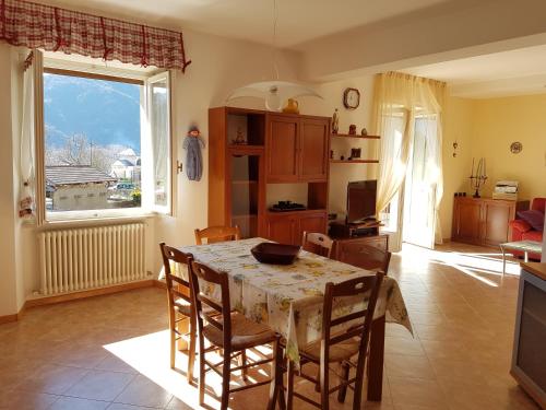 kuchnia i jadalnia ze stołem i oknem w obiekcie Casa Luca e Cristina w mieście Mezzolago