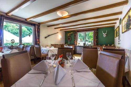un restaurant avec des tables blanches, des chaises et des fenêtres dans l'établissement Kulinarium an der Glems, à Stuttgart