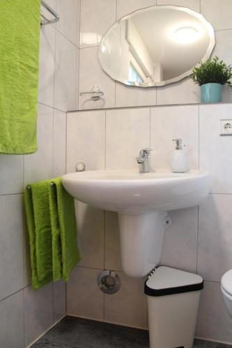 La salle de bains est pourvue d'un lavabo et d'un miroir. dans l'établissement Ferienwohnung Auf der Blumenstrasse, à Nettetal