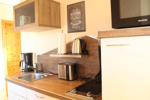 a small kitchen with a sink and a microwave at Ferienwohnung Auf der Blumenstrasse in Nettetal