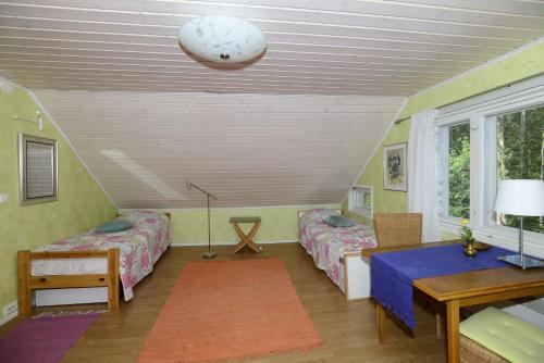 a attic room with two beds and a table at Guesthouse Torppa in Korkeakoski