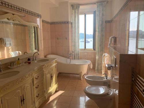 y baño con 2 lavabos, bañera y aseo. en Seagulls en Villefranche-sur-Mer