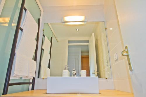 a bathroom with a sink and a mirror at Duplex 4 personnes Chambre vue mer Résidence O Coeur de Deshaies in Deshaies