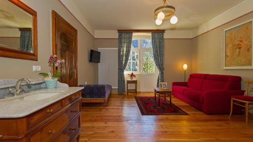 a bathroom with a red couch and a living room at Hotel Lago di Braies in Braies