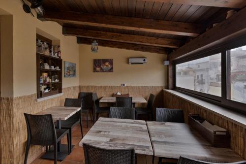 a restaurant with wooden tables and chairs and a window at B&B Le Oasi in Terrasini