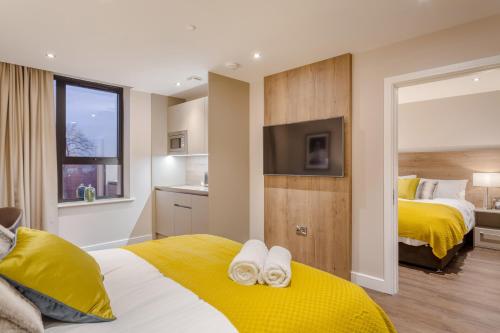 a hotel room with two beds and a television at Dwell City Living in Nottingham
