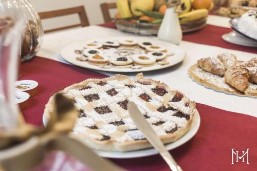 a table with a cake and pastries on it at Mulberry House in Trani