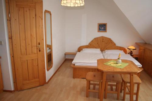 a bedroom with a bed and a table and a bed and a door at Reiterhof Sonja in Apetlon