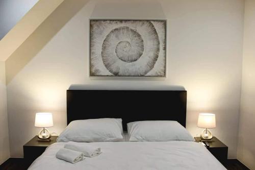 a bedroom with a large bed with two lamps at Il Galeone hotel in Stupava